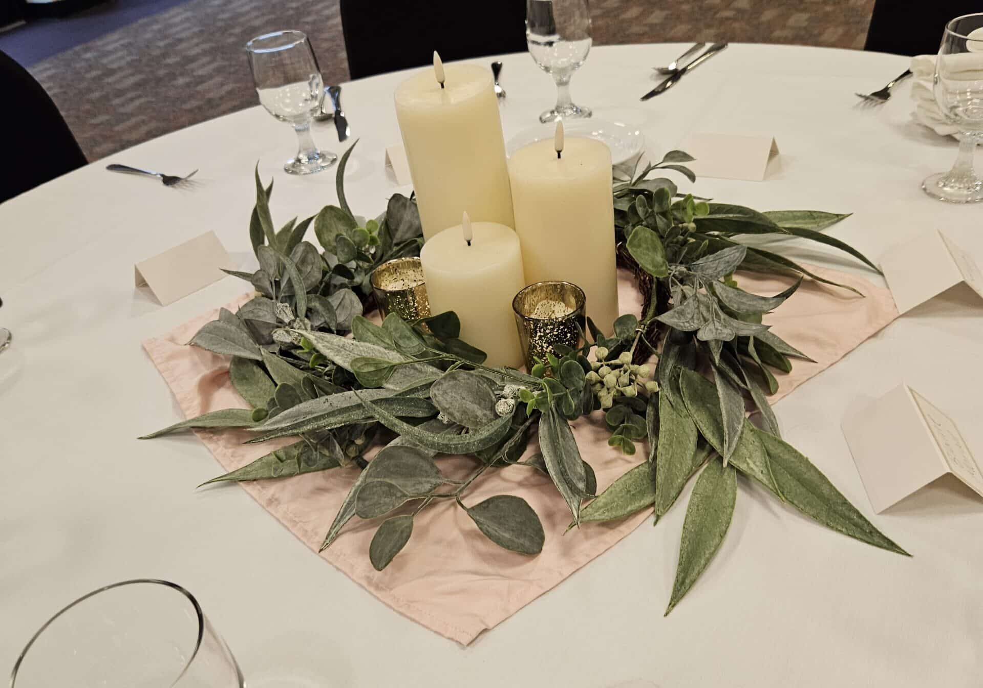 Greenery centerpiece with candles on table